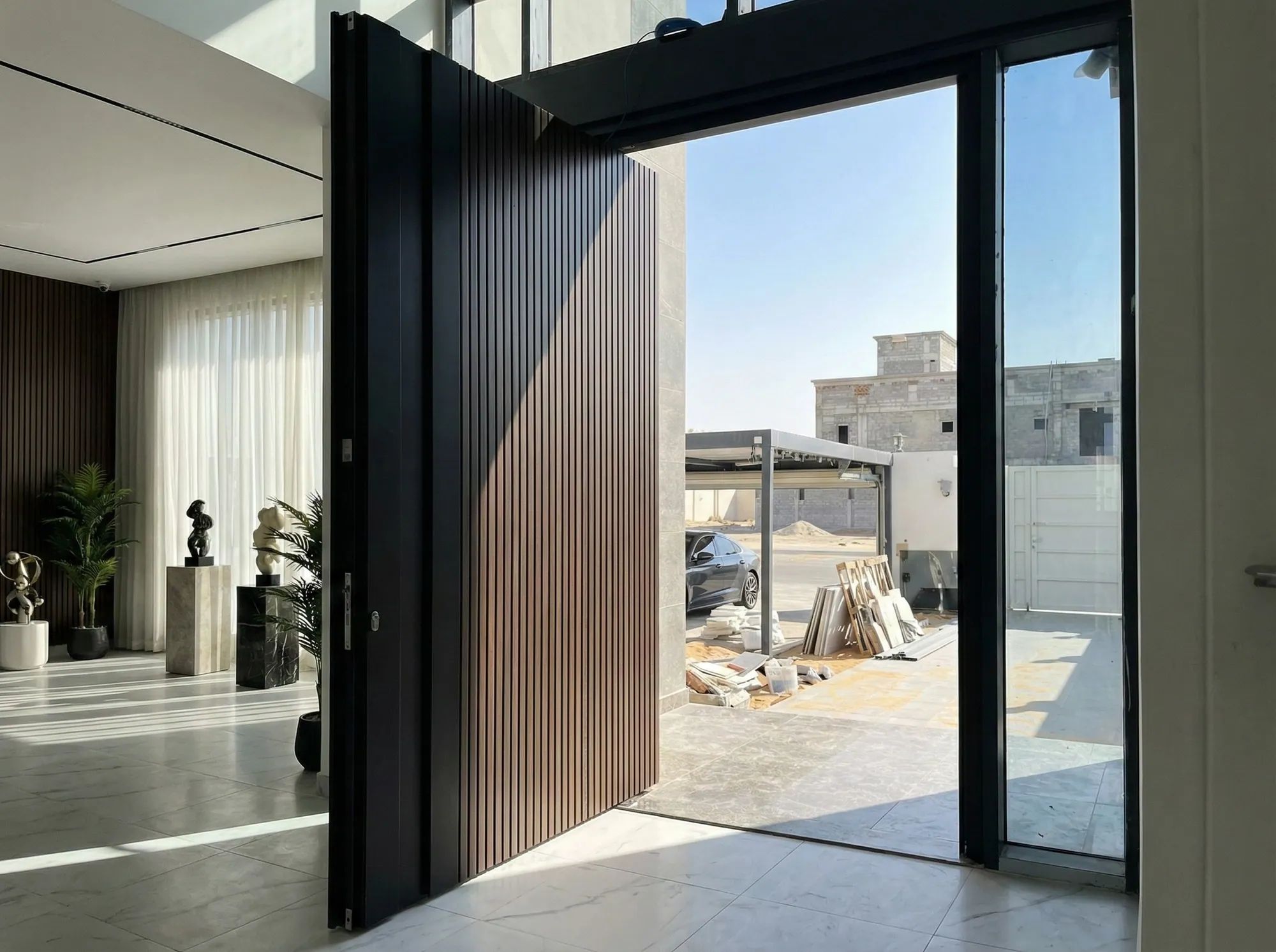 Black pivot entrance door with vertical timber slats