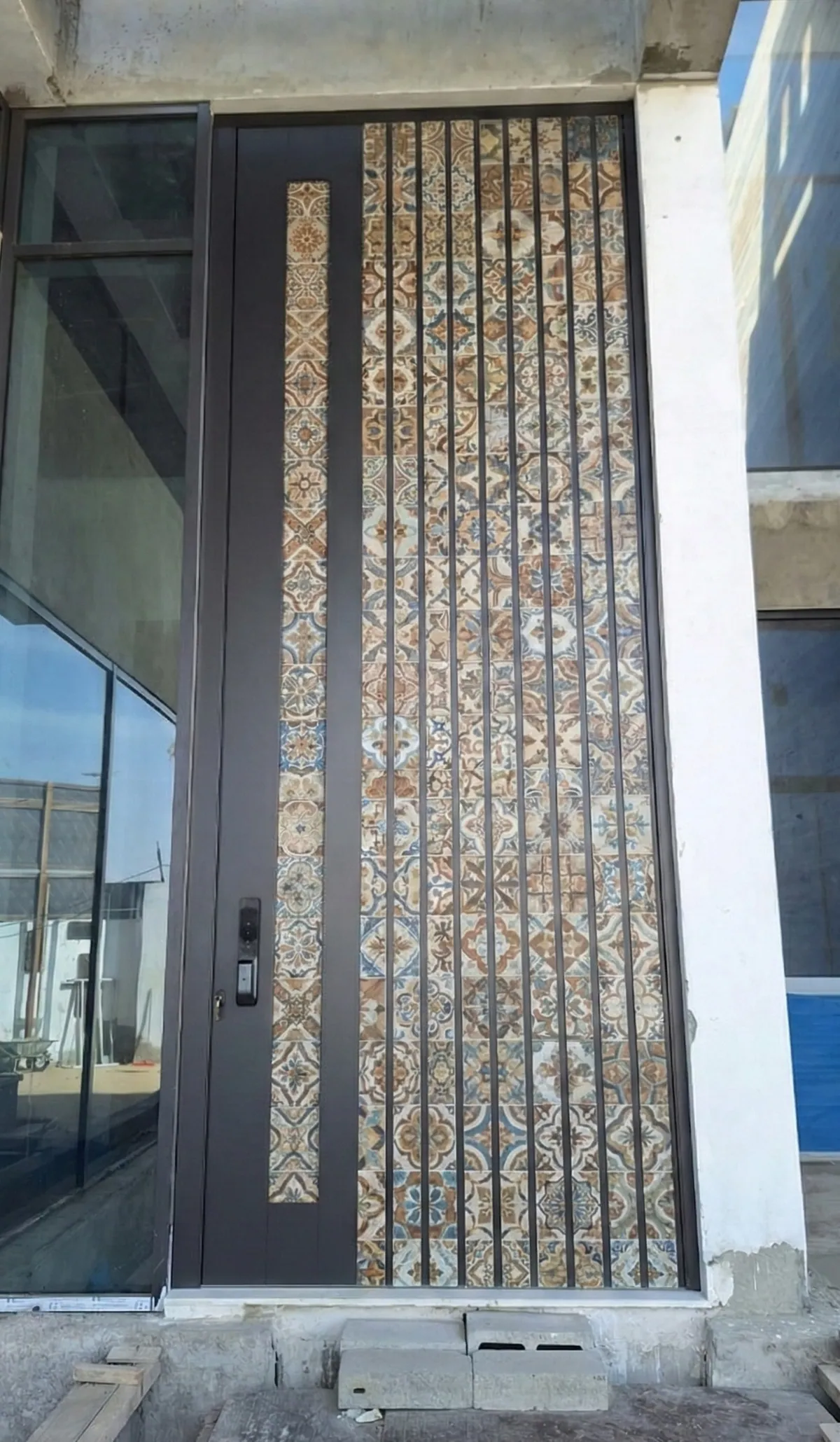 Pivot entrance door with patterned tile inlay and smart lock