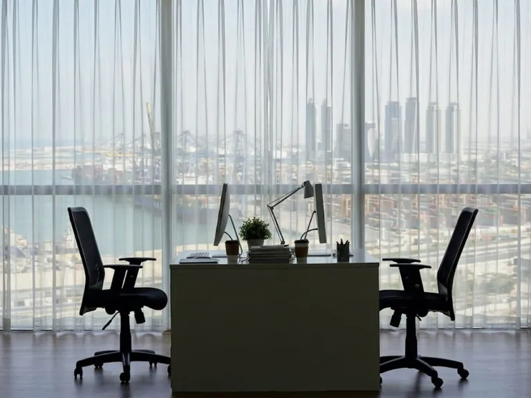 Executive desk and chairs facing a floor-to-ceiling window