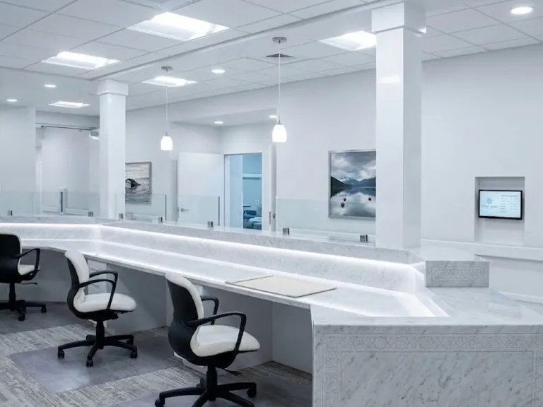 White marble clinic reception counter with staff workstations