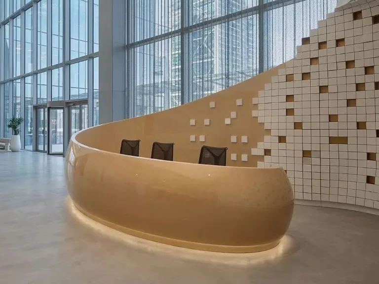 Curved backlit reception desk against a pixel-tile feature wall