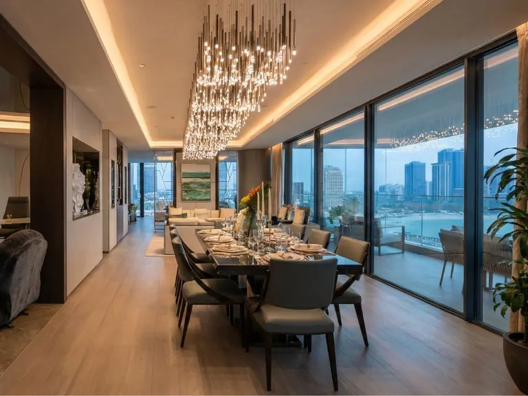 Long dining table under a crystal chandelier with city views