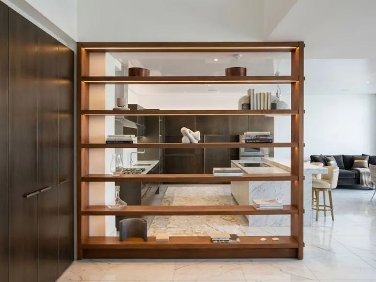 Open walnut shelving unit used as a room divider