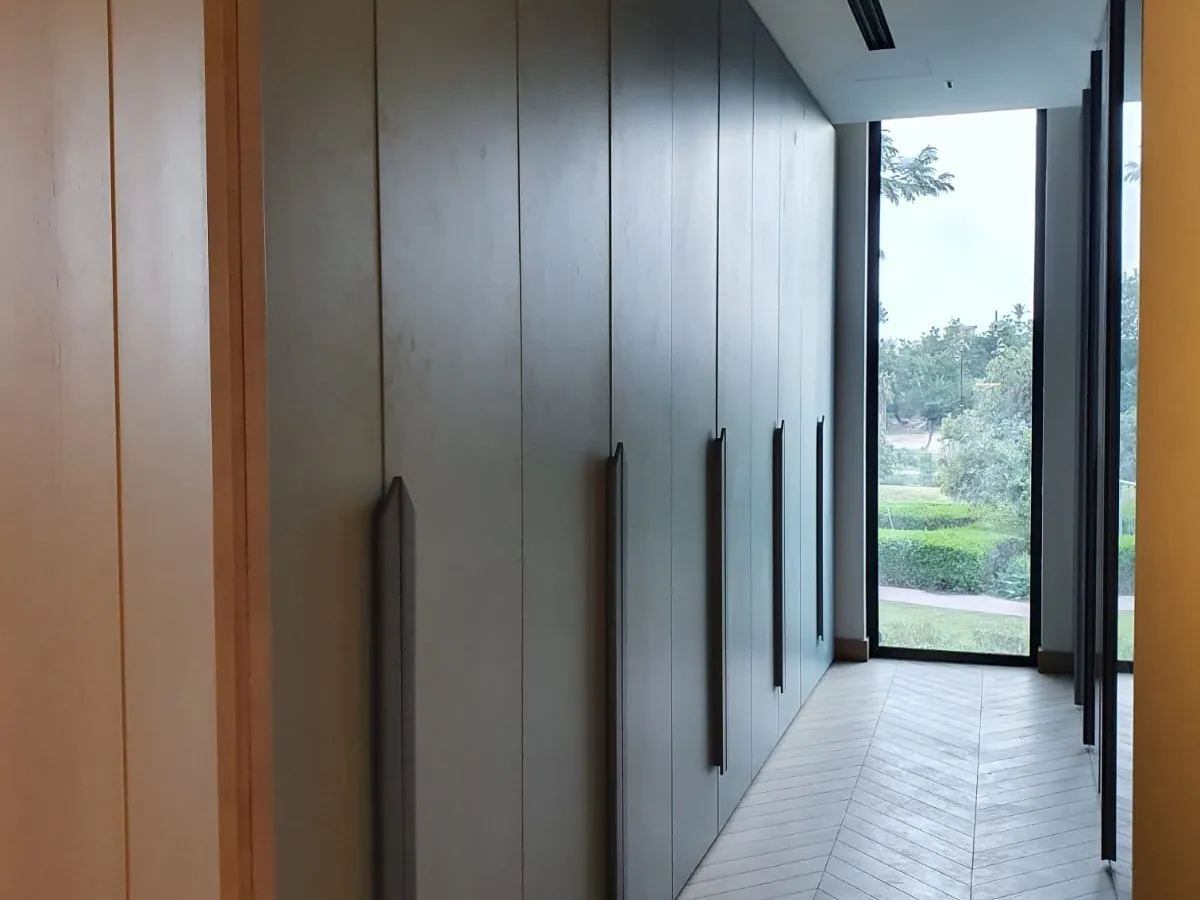 Floor-to-ceiling hinged wardrobe doors in grey with long bar handles