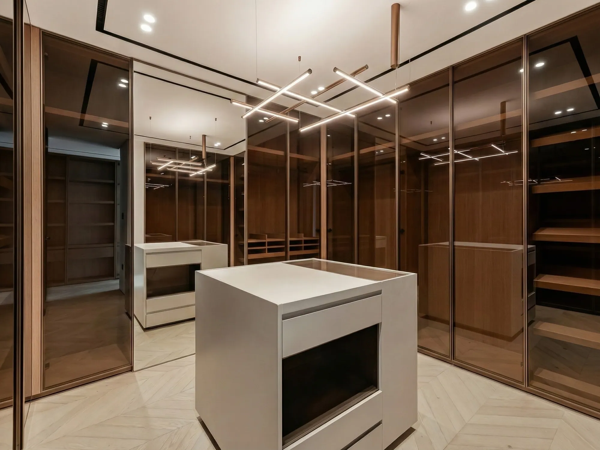 Walnut walk-in closet with smoked-glass doors, white island and linear pendants