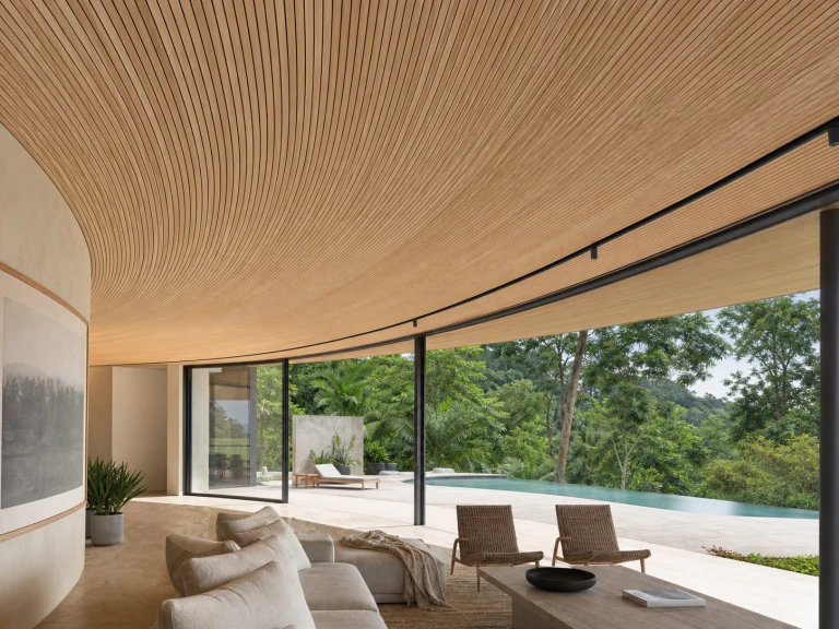 Curved slatted timber ceiling opening onto a pool terrace